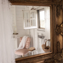 Load image into Gallery viewer, Decorative mirror with ornate frame reflecting a room with a chair and window.
