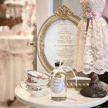 Load image into Gallery viewer, Lavender simple syrup displayed with pretty teacups and a vintage bust. 
